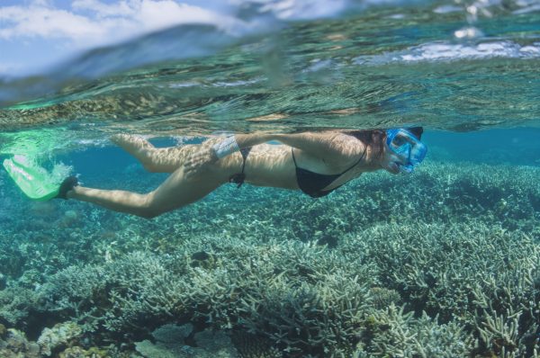 Underwater stills photographer photographing a model on a coral reef
